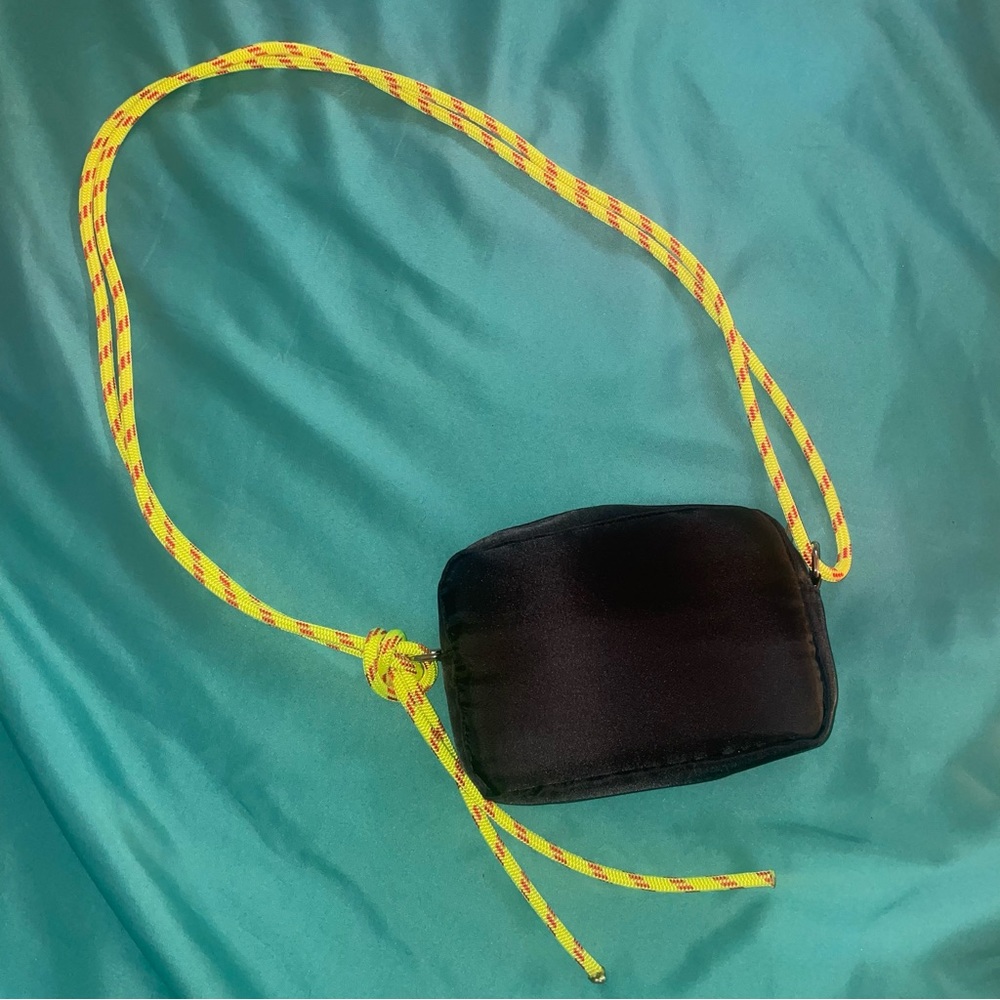 black purse with yellow rope strap